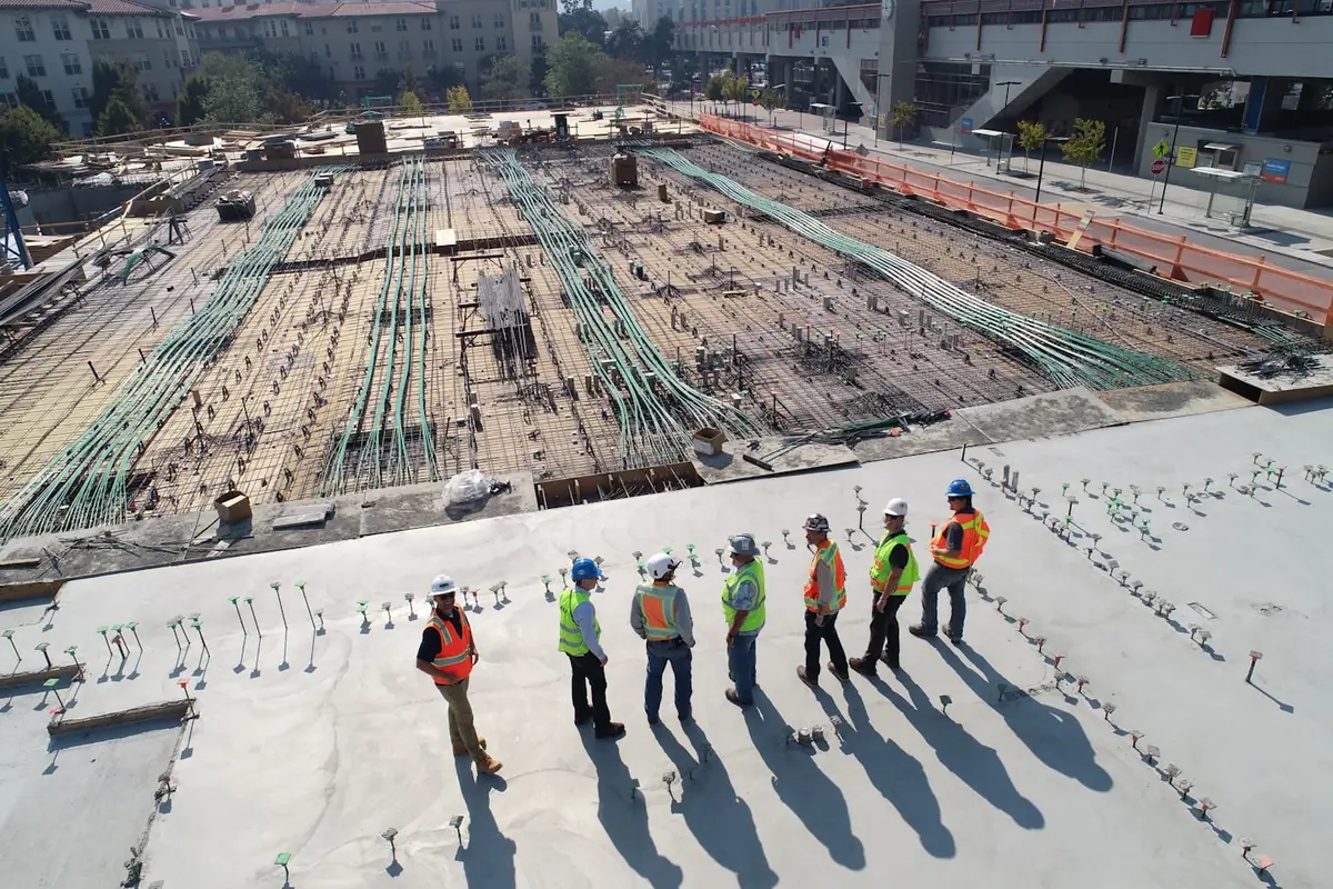 Construction workers in hard hats and hi-vis on an elevated concrete slab