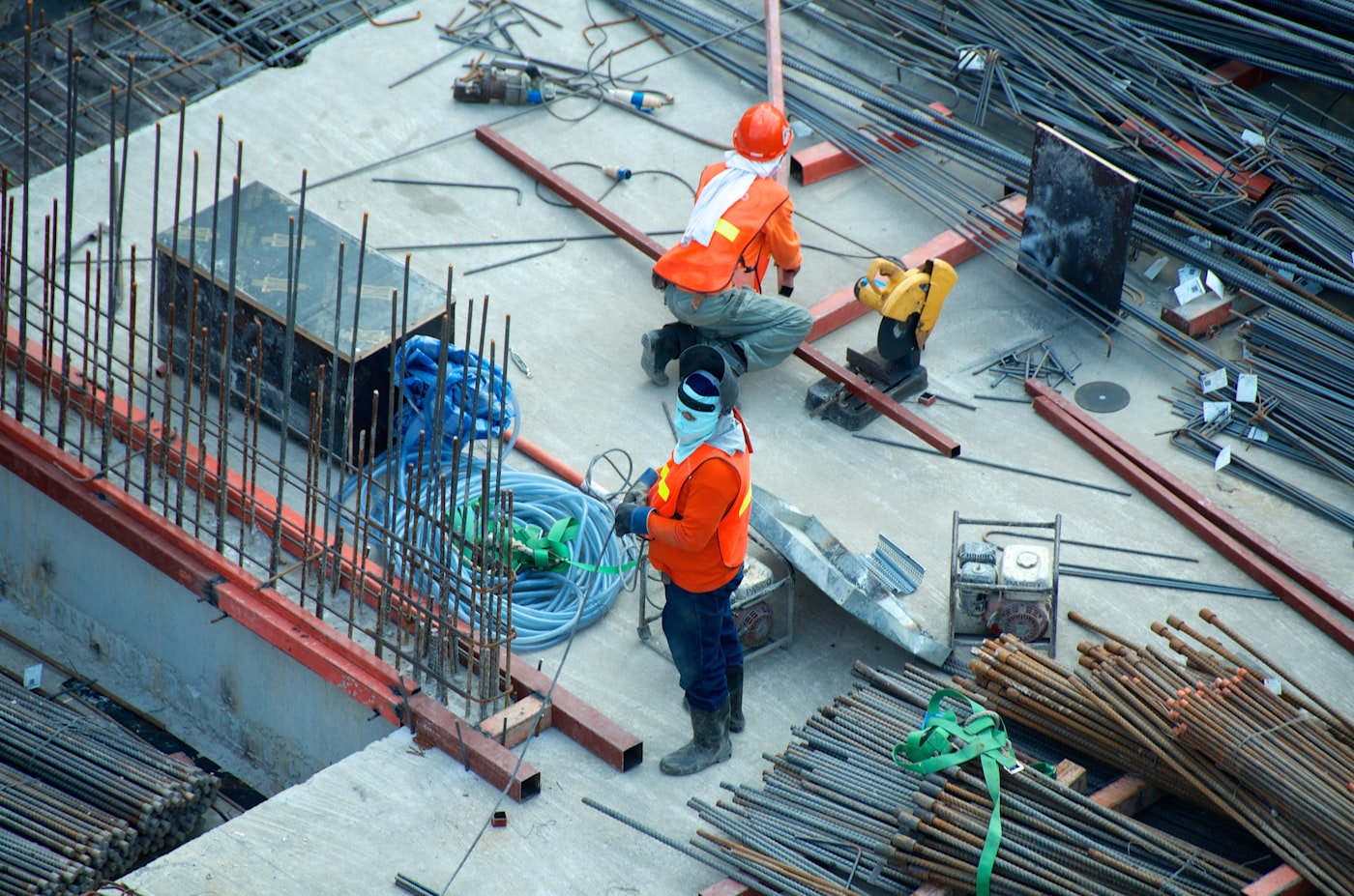 Two construction workers in high-visibility vests on site